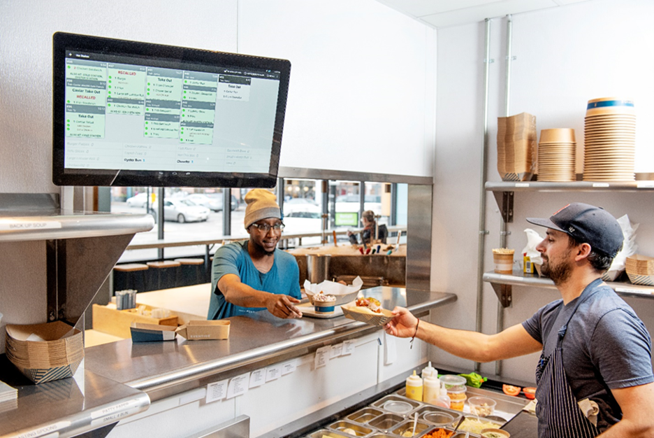 Cook passing an order through a restaurant kitchen window