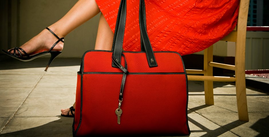 woman in a red dress sitting next to a red purse